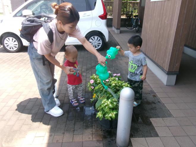 親子で寄せ植えに水やりをしている様子