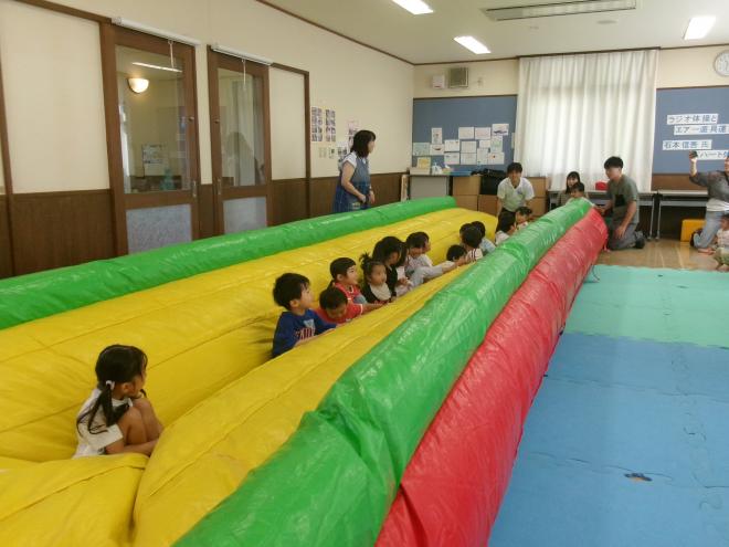 膨らみ始めたエアー遊具の上に子ども達が乗っている様子