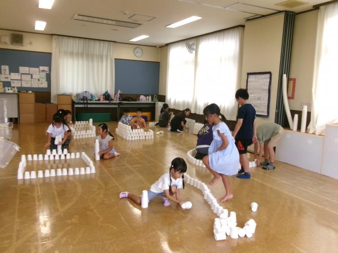 子どもたちが紙コップを積み上げている様子