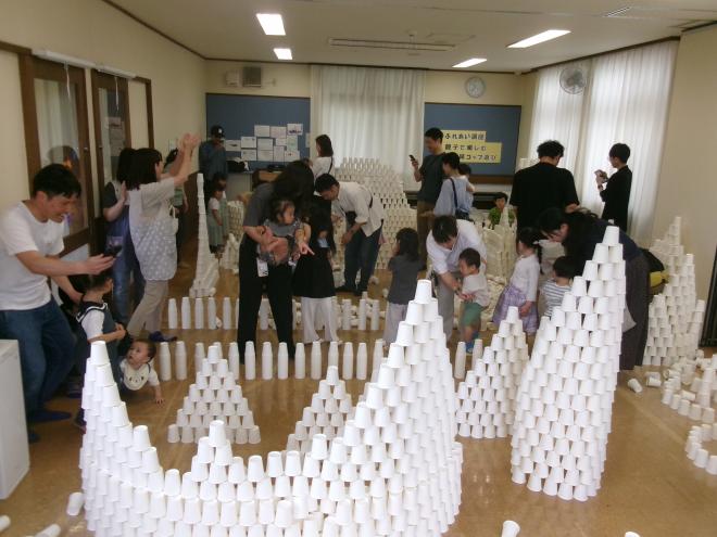 お父さんの紙コップ造形を見る様子